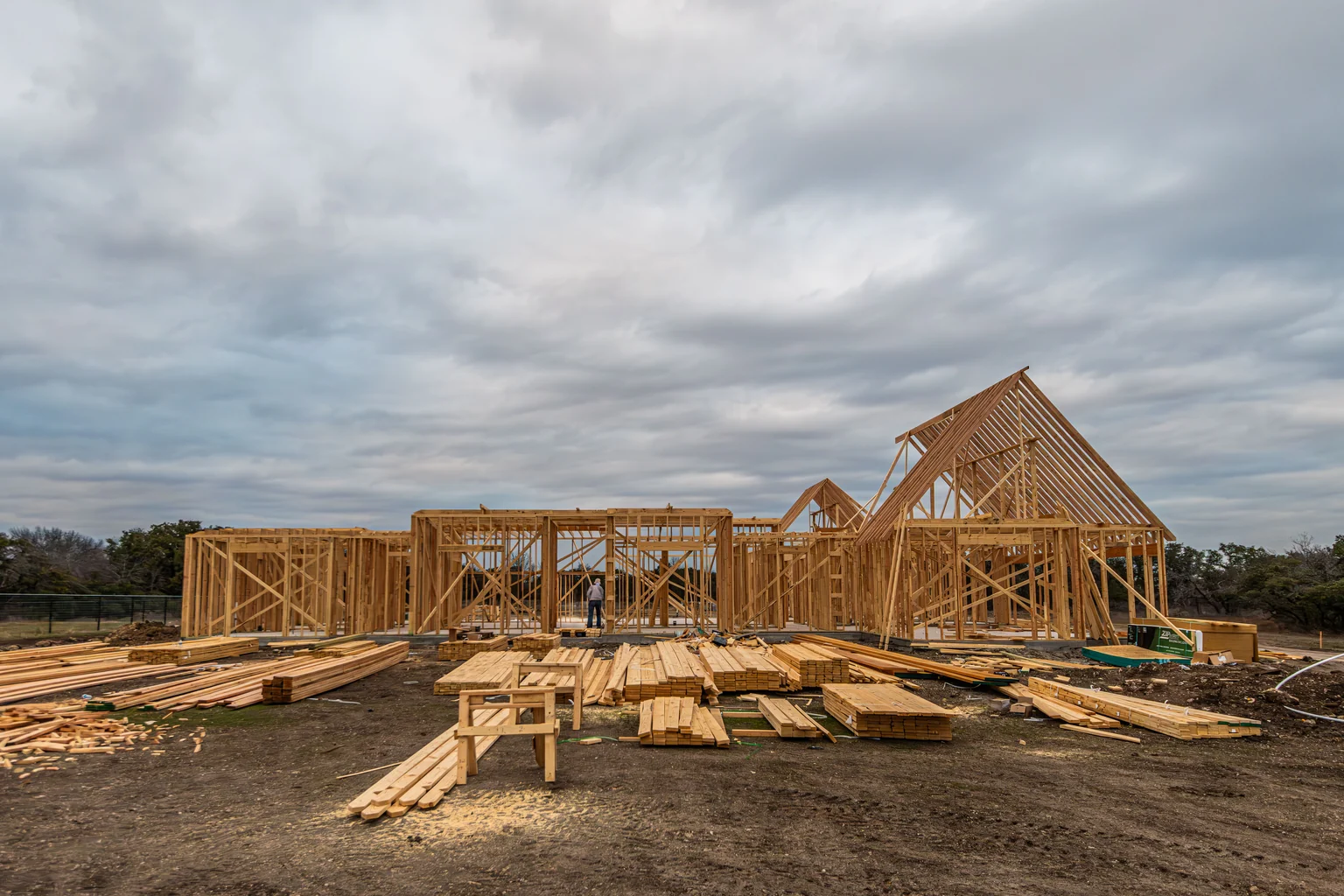 New home construction with timber roof framing and lumber on site