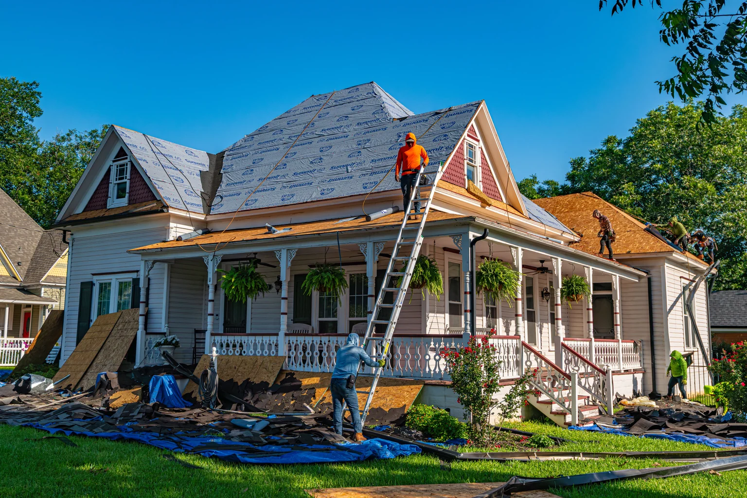 Roofers replacing the roof of a Victorian home